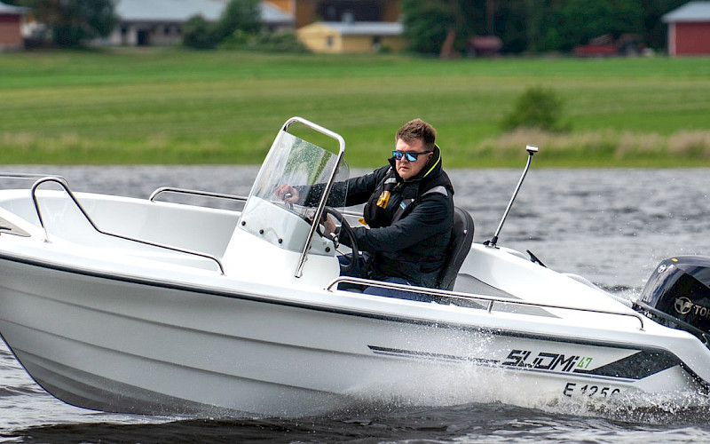 Mies ajaa suomiboats veneellä järvellä